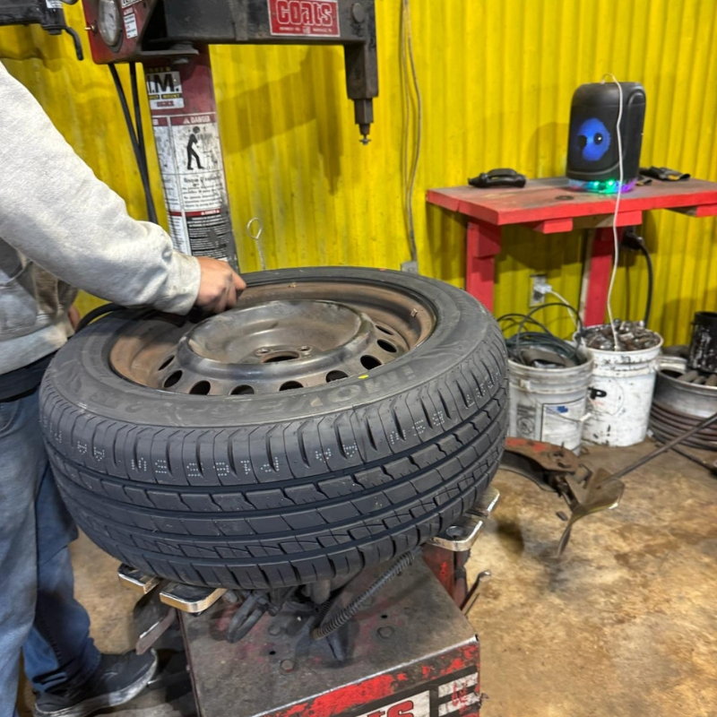 Technician mounting a tire on a Coats tire changer