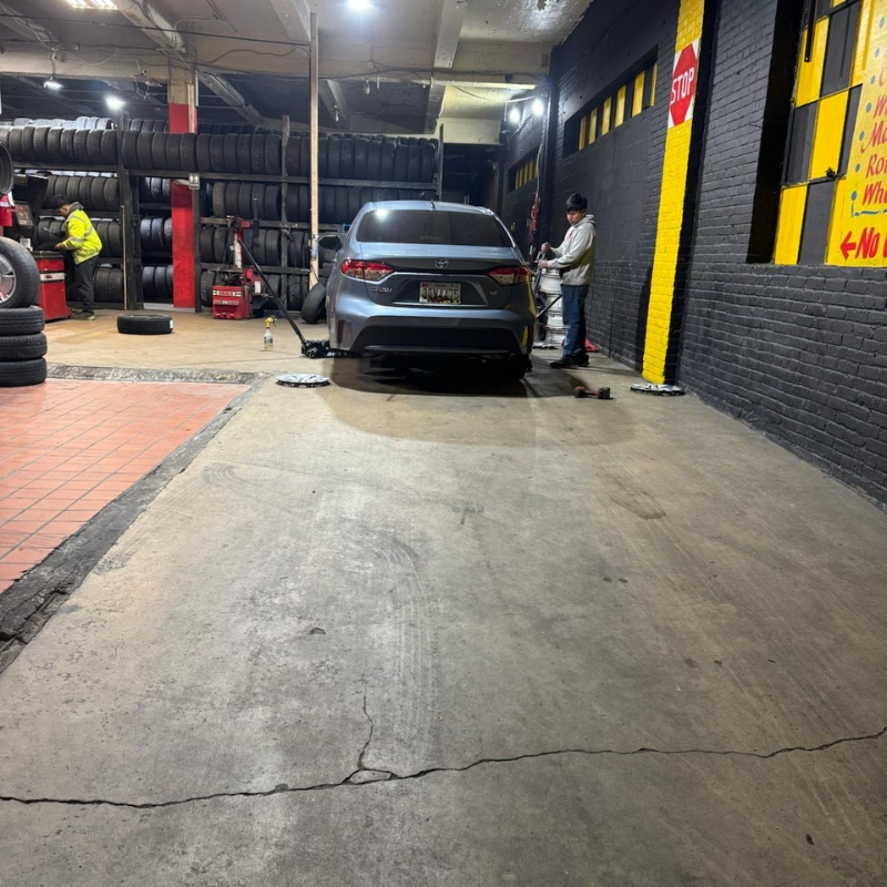 Service bay with tires in stock and vehicle being serviced