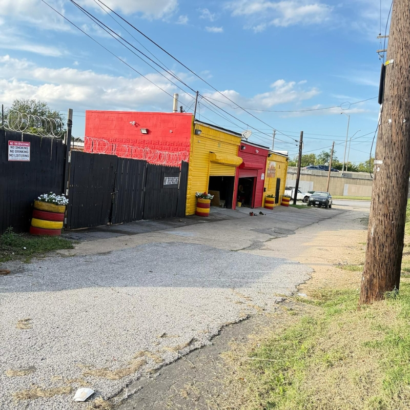 Side view of the Hanover St shop with bay door and yellow exterior