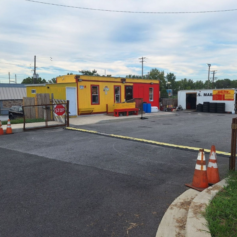 Wide view of the North Point Blvd lot with U.S. Mail truck and tires